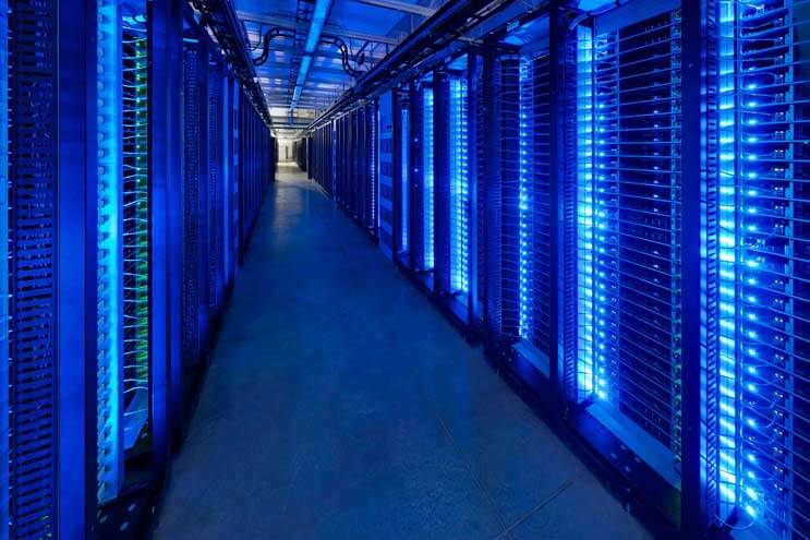 Blue-lit servers blink inside the Facebook data center in Prineville, Oregon, the hub of the company’s global infrastructure. (Photo: Alan Brandt for the Open Compute Project)